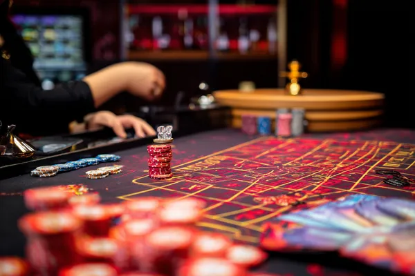 A glowing roulette wheel with cascading chips, symbolizing the engaging live and instant-win games available on FONBED.